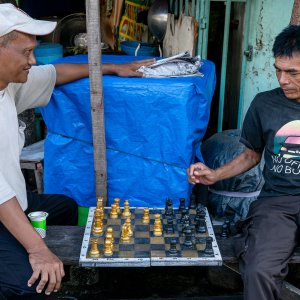 住宅街の町角でチェスをする男
