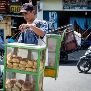 Young man peddling breads with a carrying pole