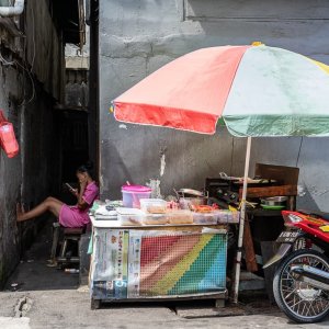 Woman relaxing behind the food stall