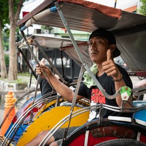 Becak driver thumbing up strongly