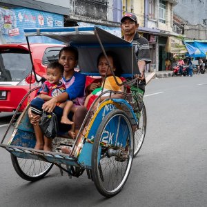 Becak running with parents and children