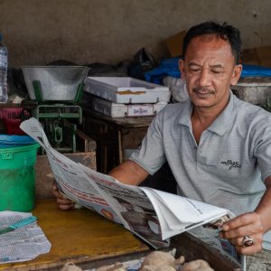 Man leisurely reading a newspaper