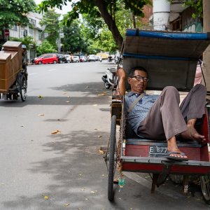 Man taking a nap on a Becak