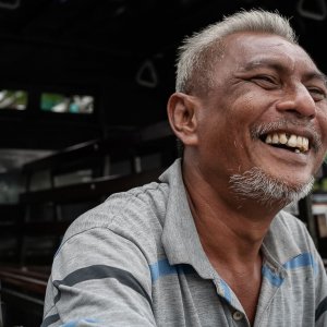 Man with gray hair laughing loudly