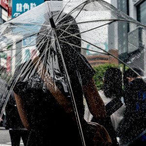 ビニール傘を差す若い女性