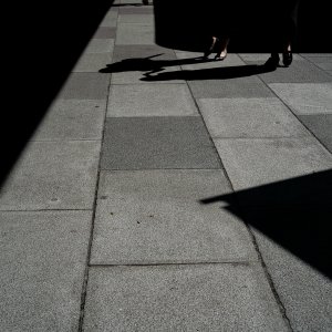 Women's legs walking between shadows