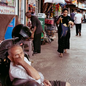 Man leaning against a motor scooter