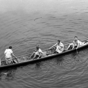 Young Buddhist monks on wooden boat