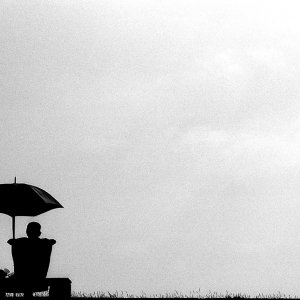 SIlhouetted man relaxing under sunshade