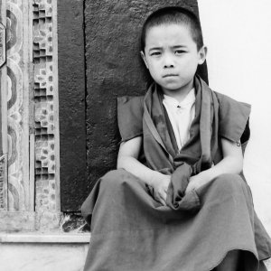 階段に腰掛けた幼い僧侶