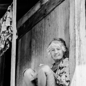 Woman with silver hair sitting under eaves
