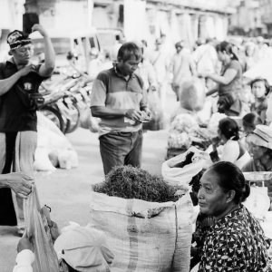 道端に袋を並べて野菜を売る女たち