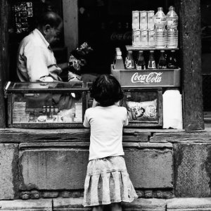 Girl buying candies in small shop