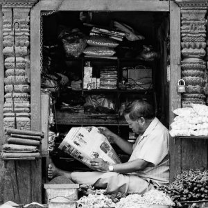 Storekeeper reading newspaper