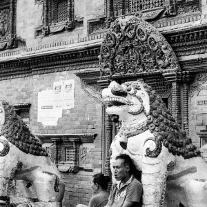 Man leaning against statue of lion