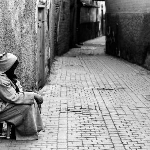 Woman sitting in an empty Marrakesh alley