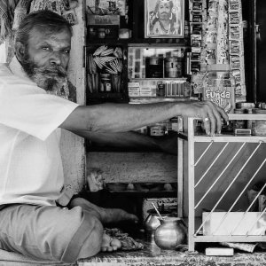 Man sitting cross-legged in a small store