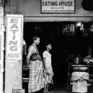 Two men standing in front of eating house