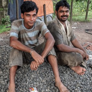 Men sitting on gravel