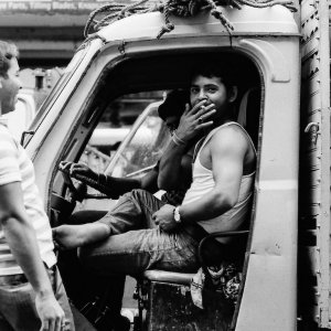 トラックの中で煙草を吸う男