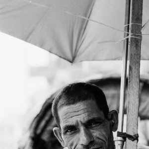 Man waiting for customers under sunshade