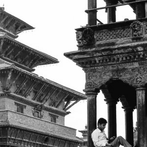 Man relaxing under the eaves of the Krishna Temple
