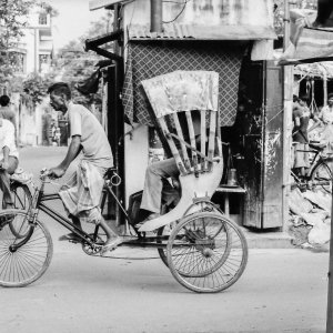 路地を横切って行くサイクルリクシャー