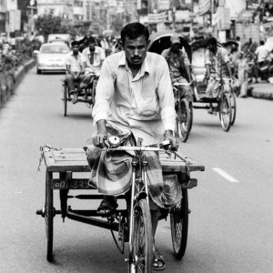 Man pedaling the tricycle with cart