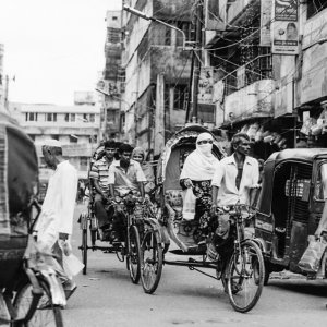 Cycle rickshaw with passenger running