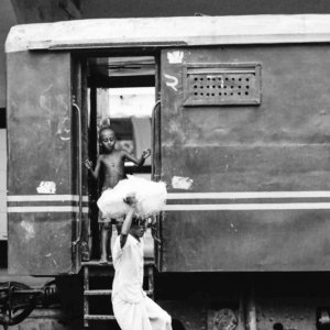 boy on platform and man carrying burden