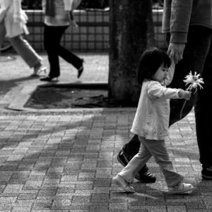 花を持って歩く幼い女の子