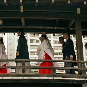 木製の橋を渡る結婚式の参列者