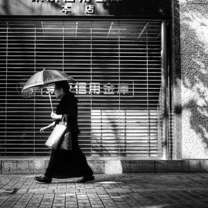 Older woman putting umbrella up