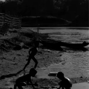 Silhouetted kids playing around on dry riverbed