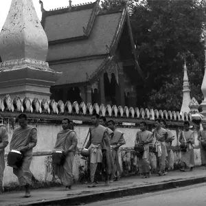 托鉢用の鉢を抱えて歩く僧侶たち