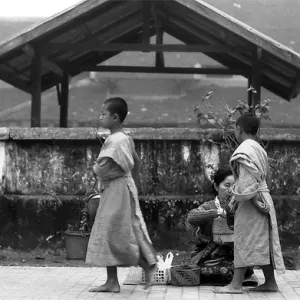 Two little Buddhist monks asking for alms