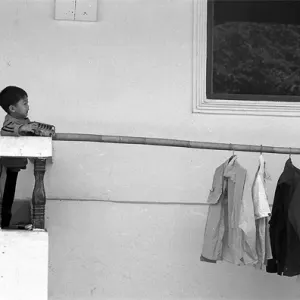 洗濯物のあるベランダで遊ぶ男の子