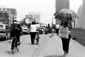 日傘を差して橋の上を歩く女性