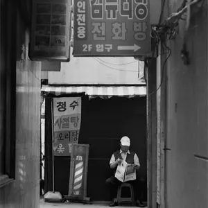 Man reading newspapre in backstreet