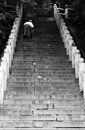 Older woman climbing steep stairway