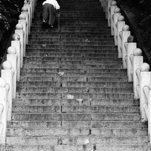 Older woman climbing steep stairway