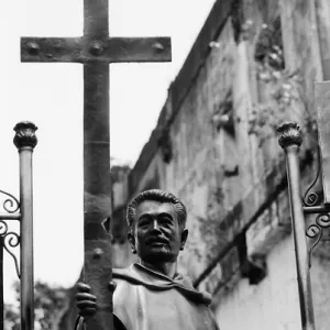 Statue of father holding a cross in its hand
