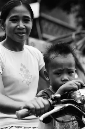 Boy riding motorbike with mother