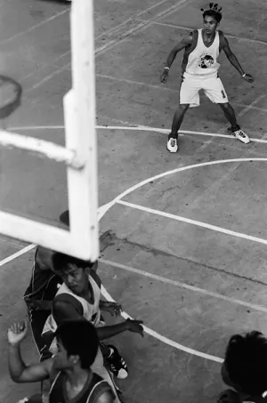 Young men playing basketball in gym