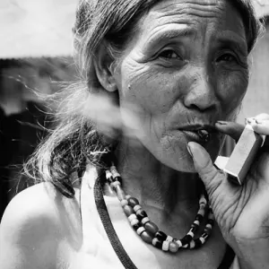 Woman puffing smoke while hlding matchbox