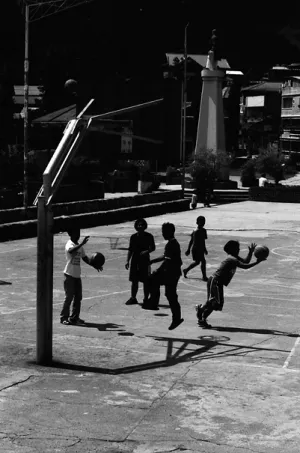 Silhouetted boys playing basketball