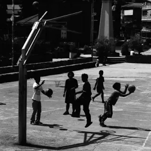Silhouetted boys playing basketball