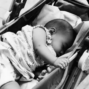 ベビーカーの中でぐっすり寝る赤ん坊