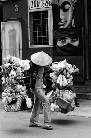 天秤棒で色々な商品を運ぶ女