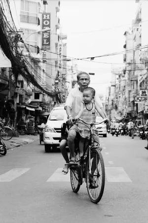 Grandfather riding bicycle with grandson